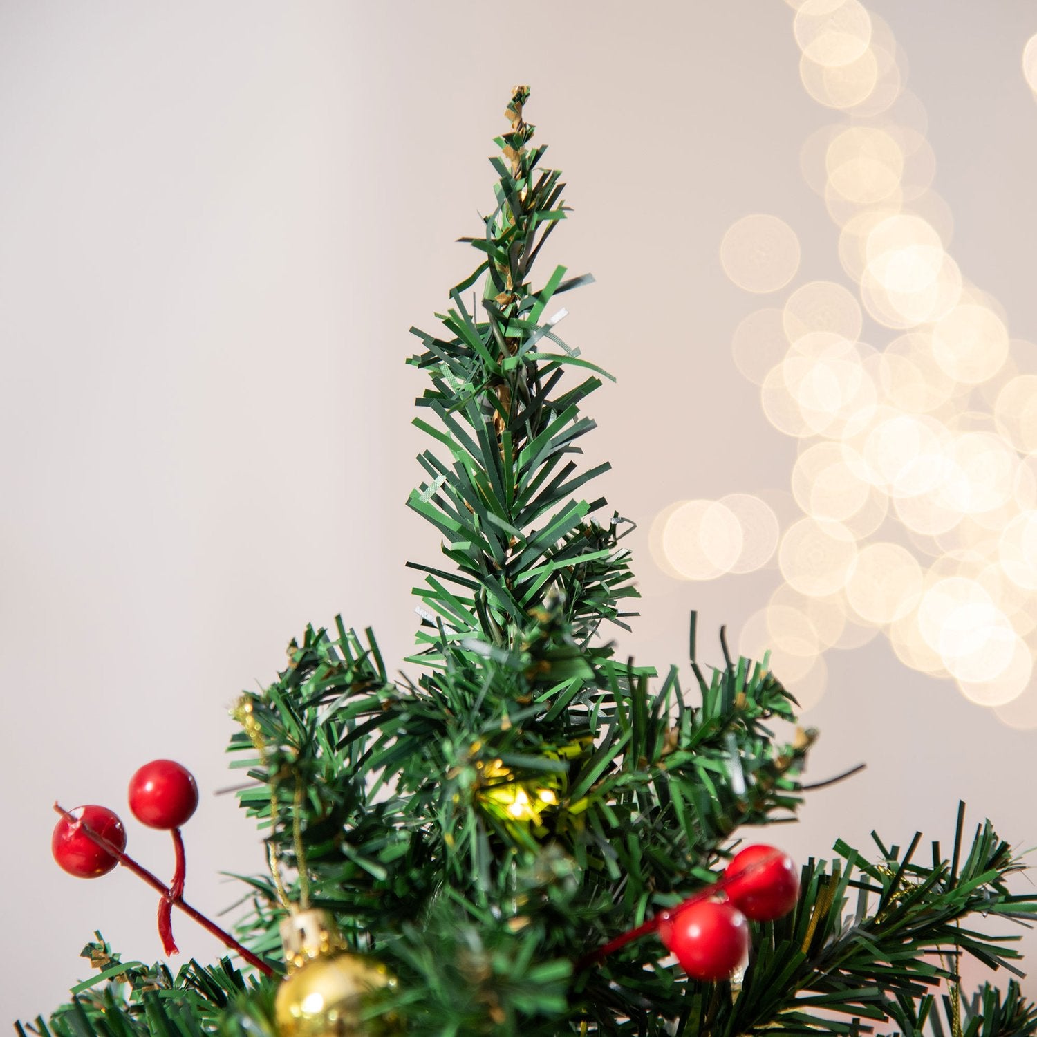 Liten grön julgran med LED-lampor och bär