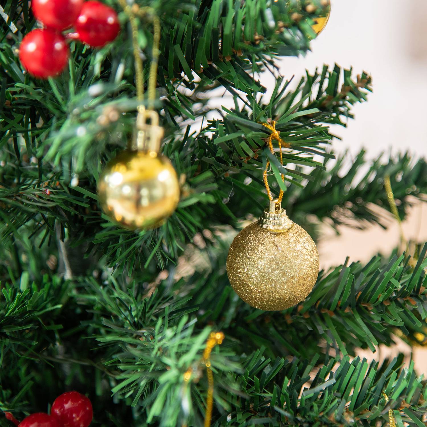 Liten grön julgran med LED-lampor och bär