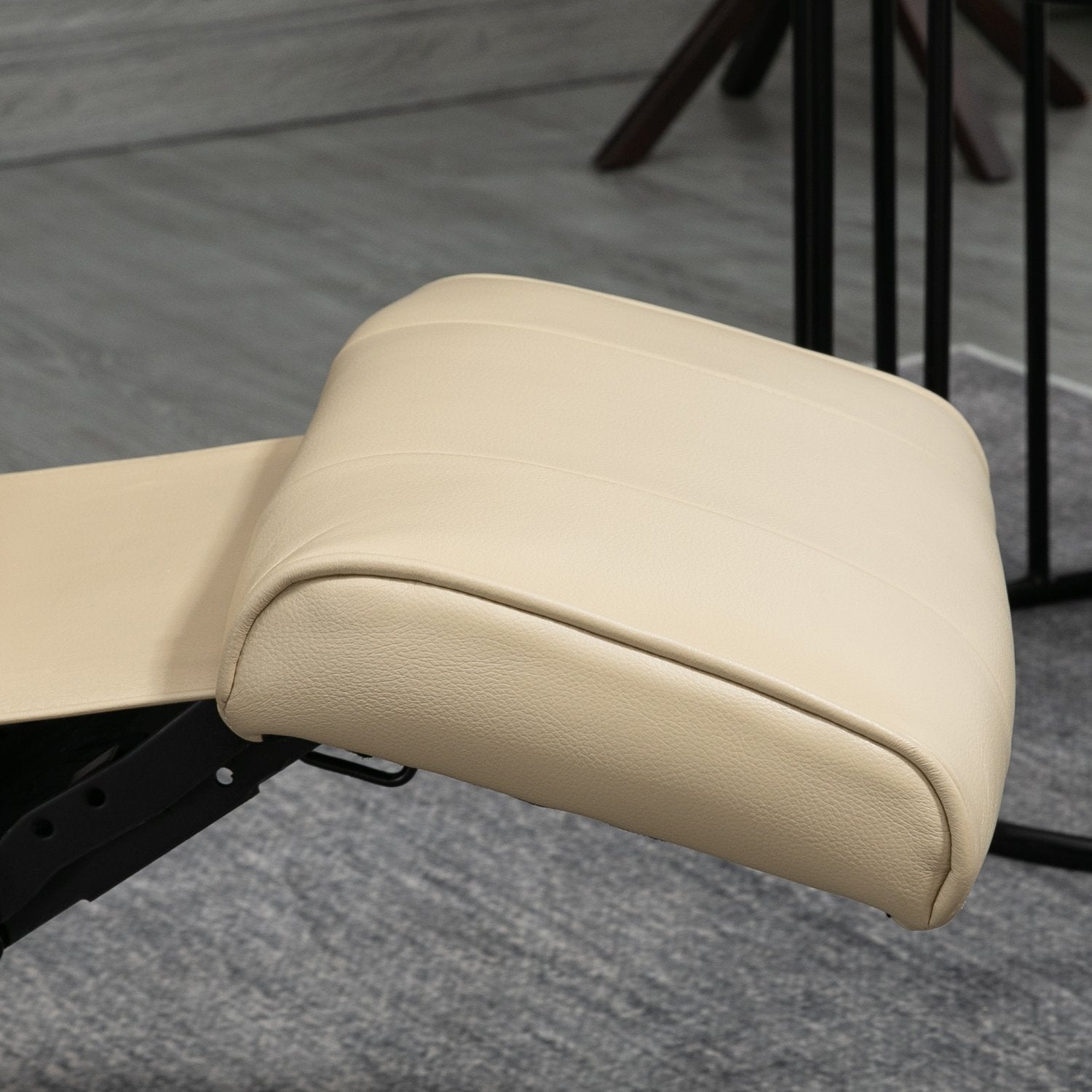 Gräddvit fåtölj i konstläder med fotstöd