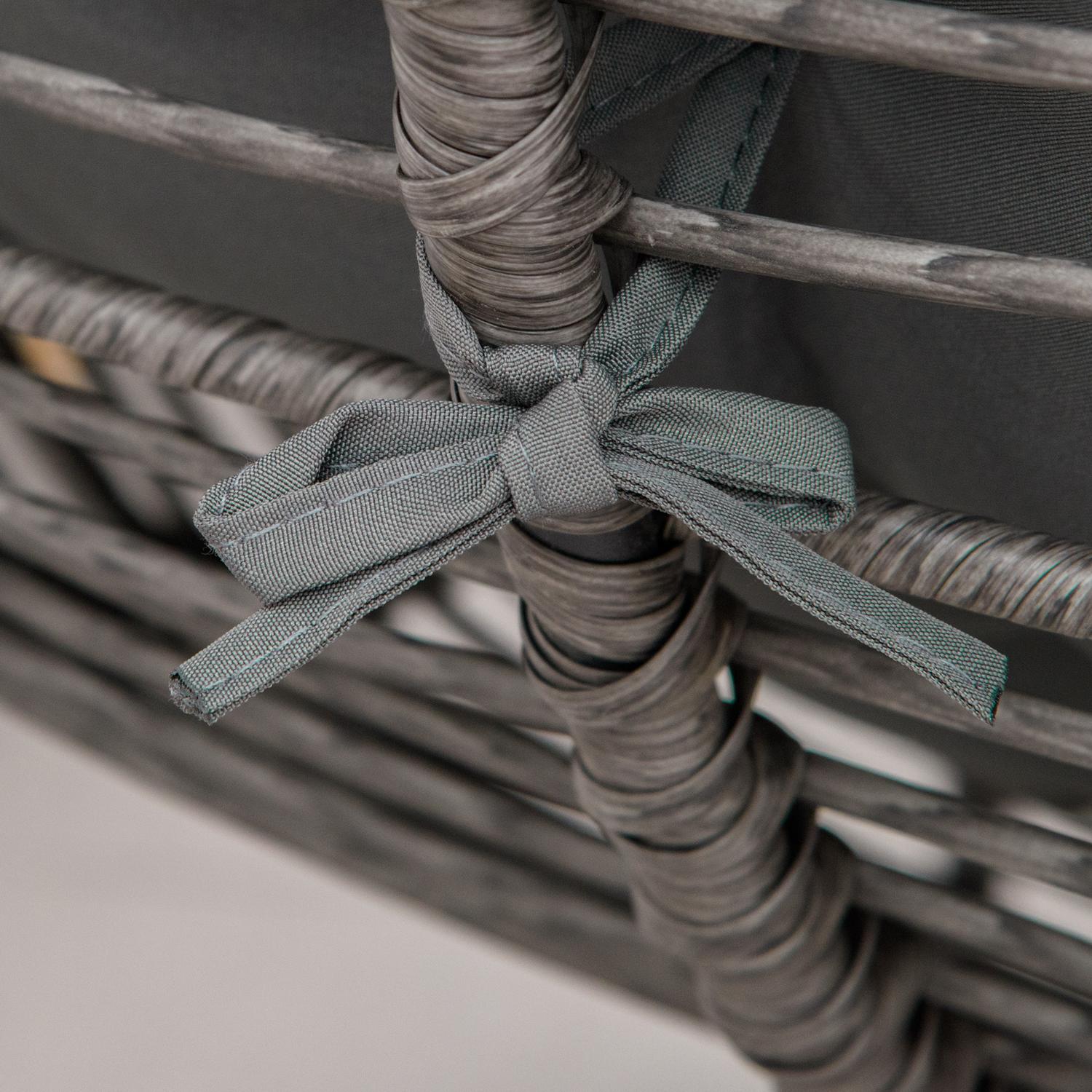 Avkopplingsstol i rotting utomhus med fotpall och gråa kuddar