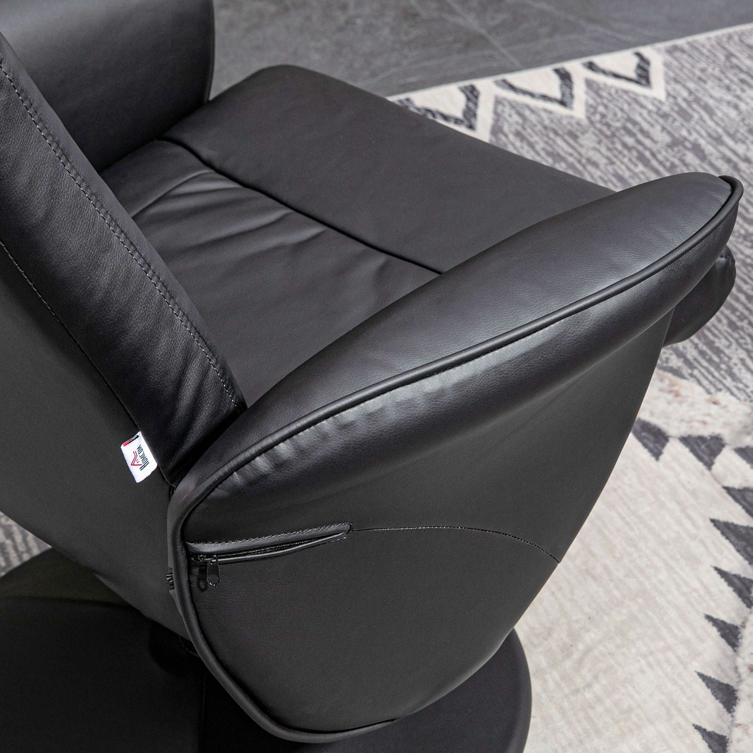 Svart lutande snurrstol i konstläder med pall