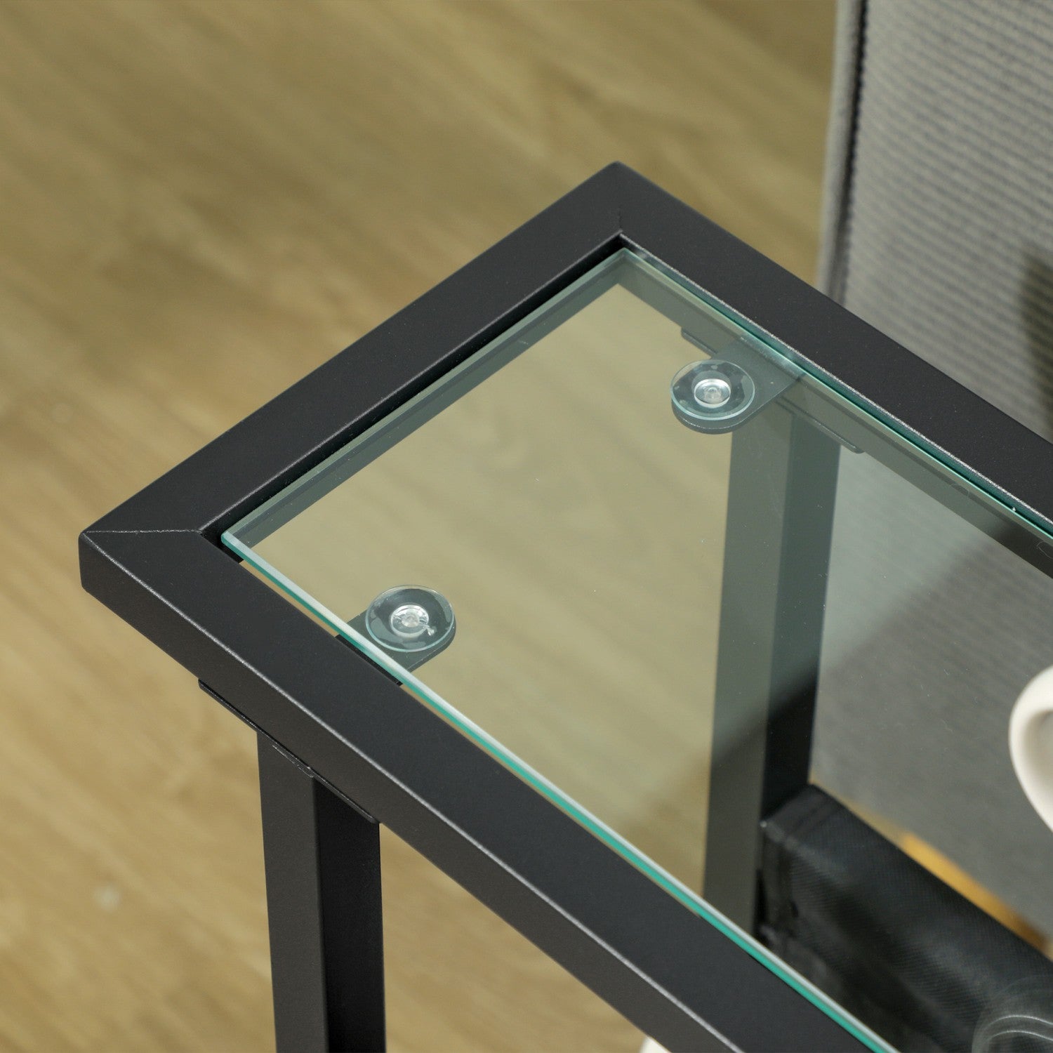 Svart sidobord i metall och glas med förvaringsväska i tyg